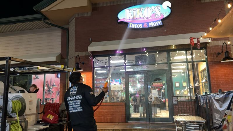 POW crew pressure washing a restaurant storefront