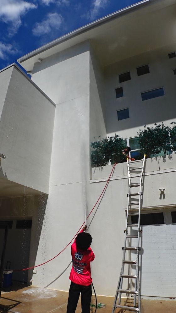 Rinsing high walls on a house wash