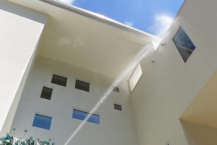Soft washing the upper walls of a white home
